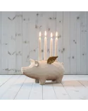 4er-Kerzenständer Schwein weiss-gold aus Holz - für Stabkerzen - auf Boden vor weisser Holzwand