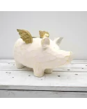 4er-Kerzenständer Schwein weiss-gold aus Holz - für Stabkerzen - auf Ablage vor weisser Wand